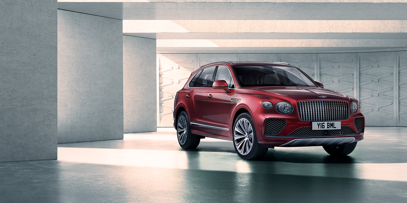 Bentley High Wycombe Bentley Bentayga Atelier Edition SUV in Rubino Red paint front three quarter against textured concrete wall