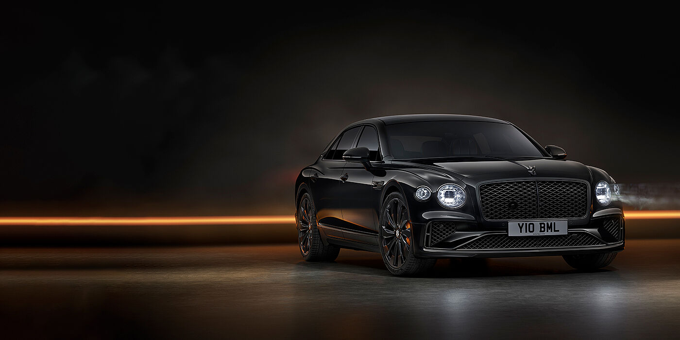 Bentley High Wycombe Bentley Flying Spur Black Edition sedan in Black Crystal paint against a dark grey and copper coloured background