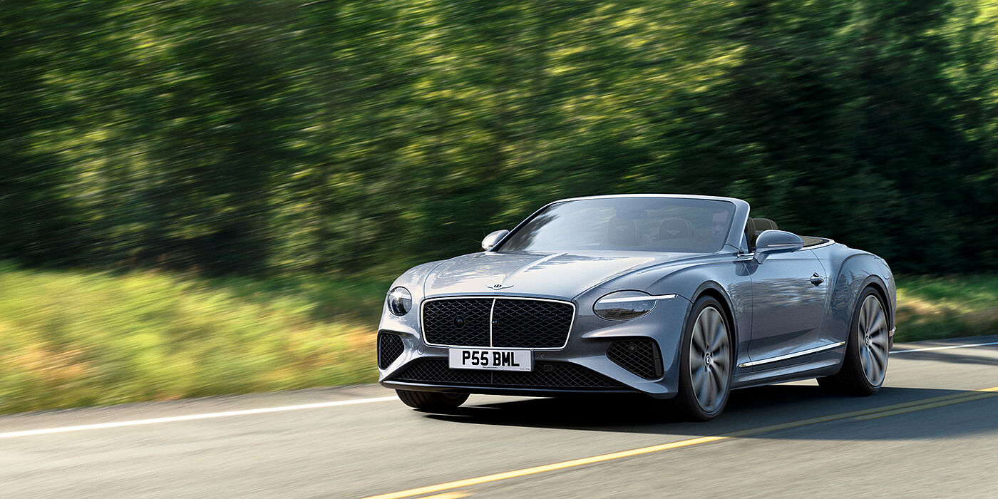 Bentley High Wycombe New Bentley Continental GTC convertible front view in Silverlake paint with 22 inch ten spoke wheels, driving dynamically on a country road